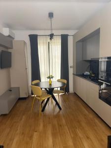 a dining room with a table and chairs and a kitchen at Lili room in Focşani