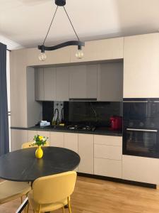 a kitchen with a black table and yellow chairs at Lili room in Focşani
