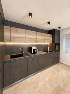 a kitchen with a sink and a microwave at Apartman Šarić in Neum