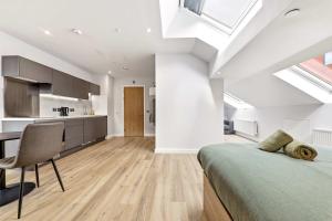 a bedroom with a bed and a desk and a kitchen at Modern Studio in Central Leeds in Leeds