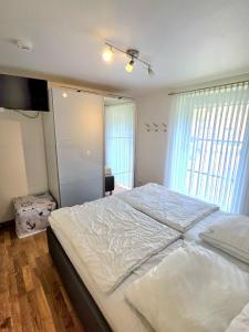 a bedroom with a large white bed in a room at Köhler-Glowienka, Ute App Nr 3 in Schönberger Strand