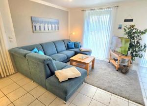 a living room with a blue couch and a table at Köhler-Glowienka, Ute App Nr 3 in Schönberger Strand +18 photos