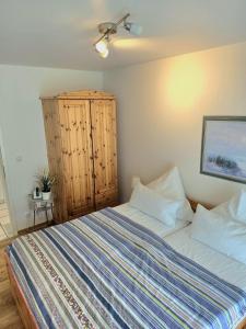 a bedroom with a bed and a wooden cabinet at Köhler-Glowienka, Ute App Nr 3 in Schönberger Strand