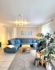 a living room with a blue couch and a table at Köhler-Glowienka, Ute App Nr 3 in Schönberger Strand