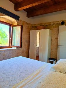 a bedroom with a bed and two windows at Casa Rurale Pietra Bianca in Roccamorice