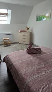 a bedroom with a bed and a dresser at Le Goeland in Beauvoir