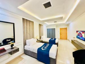 a hotel room with two beds and a flat screen tv at Ambassador Hotel in Lahore