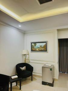 a living room with a chair and a painting on the wall at Ambassador Hotel in Lahore +24 photos