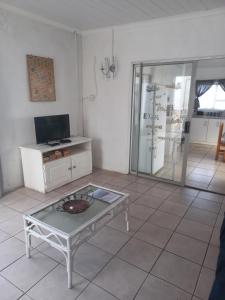 a living room with a coffee table and a glass door at Die Waenhuis in Arniston