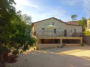 a large building with a balcony and an umbrella at Casa Rurale Pietra Bianca in Roccamorice