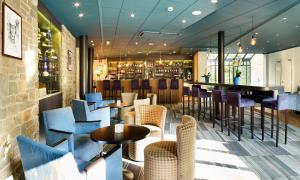 a restaurant with chairs and tables and a bar at Radisson BLU Balmoral in Spa