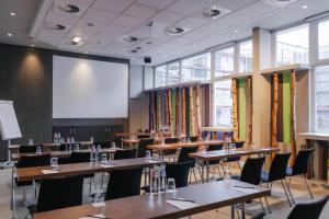 a conference room with tables and chairs and a projection screen at Radisson BLU Balmoral in Spa +120 photos