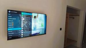 ein Flachbildfernseher, der an einer Wand hängt in der Unterkunft CAMMS 2 Studios in Rufisque