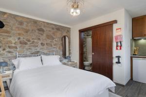 a bedroom with a bed and a stone wall at Casa do Monte - Monção in Poças do Monte +12 photos