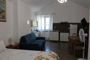 a living room with a blue couch and a kitchen at Genova Antica in Genoa