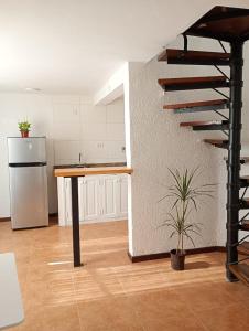 a kitchen with a spiral staircase and a refrigerator at Oro y Miel II en pleno centro de Chascomús in Chascomús