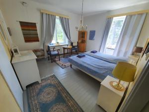 a bedroom with a bed and a living room with a desk at Knipnäs Rosengarden in Dragsvik