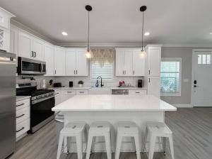 a kitchen with white cabinets and a kitchen island with stools at Charlotte NC in Charlotte