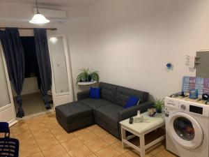 a living room with a couch and a washing machine at Aegean Overlook Studios in Parikia
