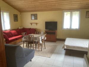 a living room with a red couch and a table at Clairbois in Gérardmer