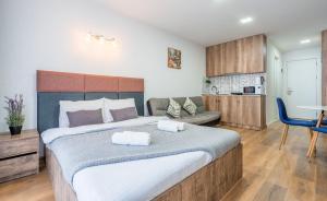 a bedroom with a large bed and a kitchen at Loft New Gudauri LT in Gudauri