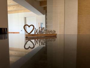 a wooden heart on a table in a room at Bulle de rêve jacuzzi in Bulle