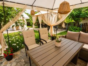 a wooden table and chairs on a patio with plants at Solmara in Lozenets