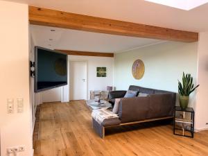 a living room with a couch and a flat screen tv at Hotel Schmidt's Hoern in Horumersiel