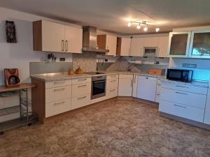 a kitchen with white cabinets and white appliances at Ferienwohnung Waldoase 