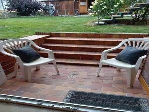 two chairs with pillows sitting on a patio at Ferienwohnung Waldoase 