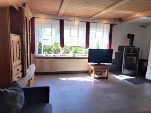 a living room with a tv and a large window at Ferienwohnung Waldoase 
