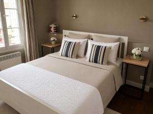 a bedroom with a large white bed with pillows at À Plus, Lectoure in Lectoure