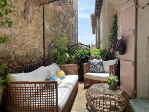 a patio with a couch and a table and chairs at À Plus, Lectoure in Lectoure