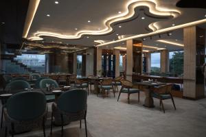 a restaurant with tables and chairs and a large ceiling at Mayur baag resort in Sāgar