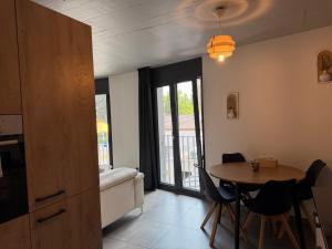 a living room with a table and a bedroom at Bulle de rêve jacuzzi in Bulle
