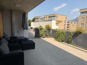 a balcony with couches and an umbrella on a building at Bulle de rêve jacuzzi in Bulle