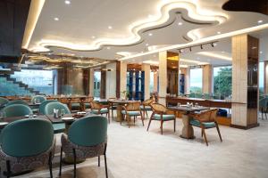 a restaurant with tables and chairs and a large ceiling at Mayur baag resort in Sāgar