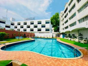 a large swimming pool in front of a building at Ambassador Hotel in Lahore