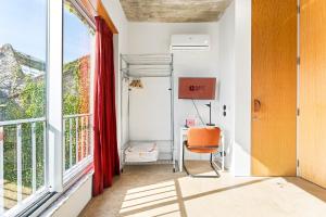 an office with an orange chair next to a window at GuestReady - Freixo Apartments in Porto