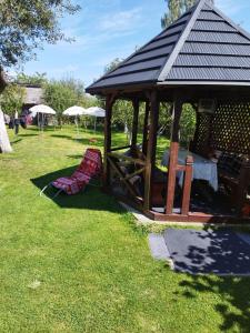 a wooden gazebo in the grass with at Casa Hirta in Ocna Şugatag +5 photos