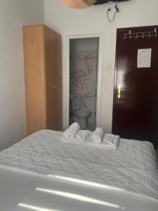 a bed with two towels and a toilet in a room at Tabacco in Obrenovac