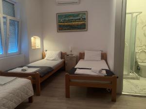 two twin beds in a room with a bathroom at Tabacco in Obrenovac