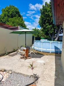 a patio with a green umbrella and a table and chairs at Penny House Hostal in David