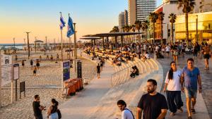 a group of people walking on the beach at bugrashov 13 room in Tel Aviv