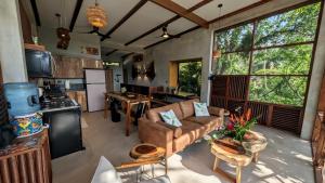 a living room with a couch and a kitchen at Beyond Alma Del Rio in Cristo Rey