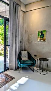 a living room with a green chair and a table at Beyond Alma Del Rio in Cristo Rey