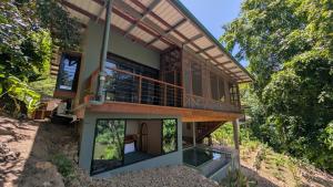 a house on the side of a hill with a balcony at Beyond Alma Del Rio in Cristo Rey