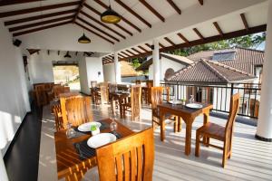 a restaurant with wooden tables and chairs on a deck at Sunset Hill Resort in Kandy