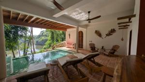 a living room with a pool and a table and chairs at Beyond Alma Del Rio in Cristo Rey