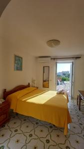a large yellow bed in a room with a window at Hotel Belsole in Forio d'Ischia +25 photos